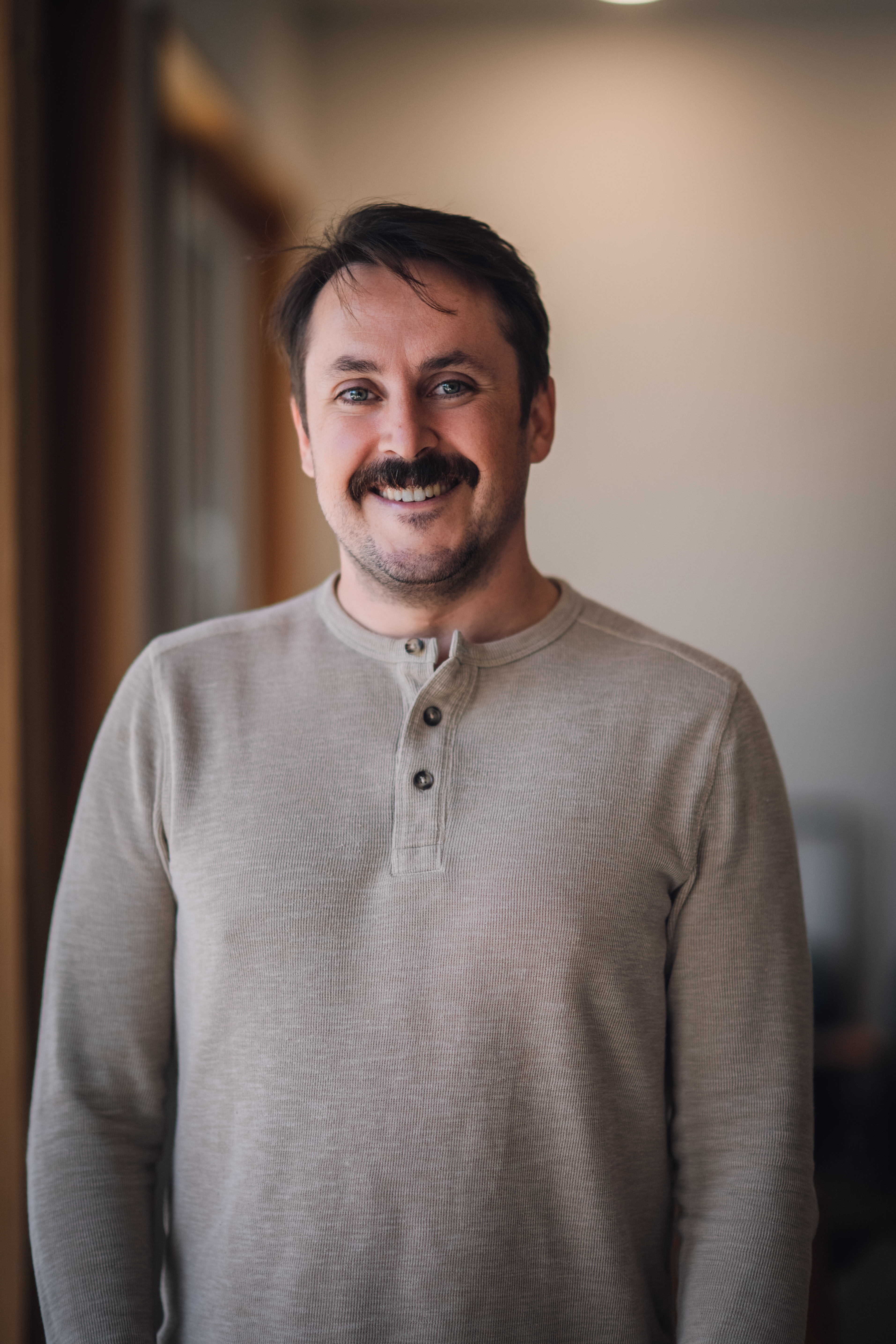 Ben Louwerse smiling, wearing a taupe shirt